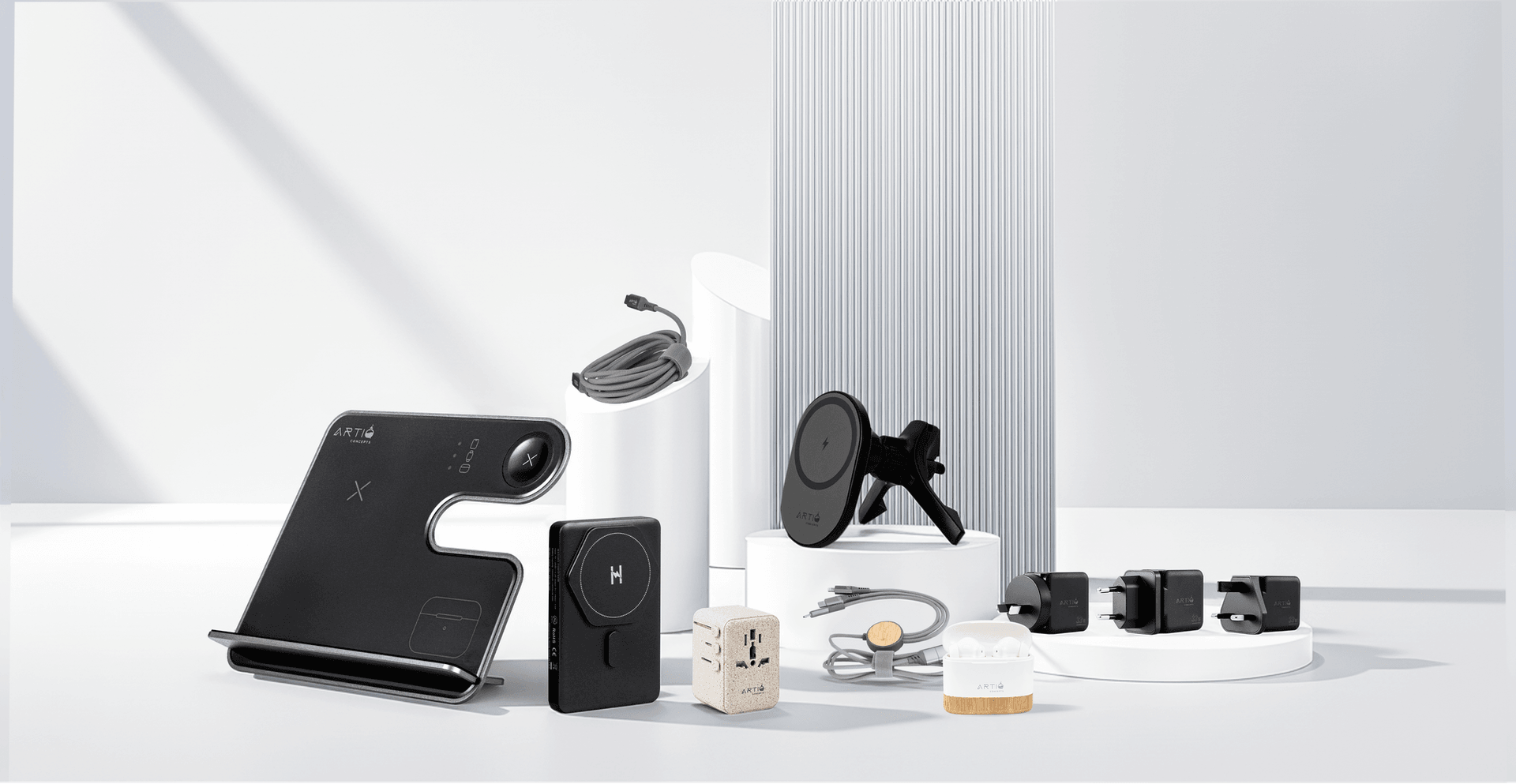 The ARTIQ range — 3-in-1 charging station, power bank, wireless car mount, travel adapter, earbuds and braided cable arranged on studio podiums
